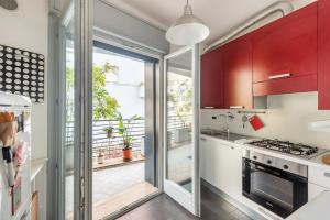 a kitchen with red cabinets and a sliding glass door at Private Condo Terrace & Parking in Rome