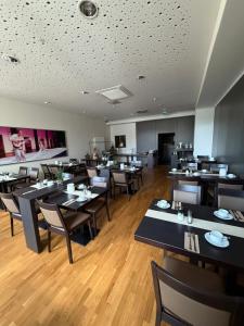 a restaurant with tables and chairs in a room at Dat Bokeltse Hus - Stadthotel Bocholt in Bocholt