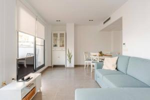 a living room with a blue couch and a tv at Apartamento Sunshine Grao in Burriana +21 photos