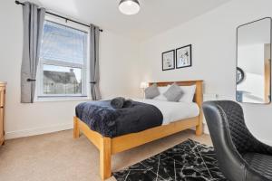 a bedroom with a bed and a chair and a window at Wolverhampton Townhouse - 3BR - Business & Leisure guests in Wolverhampton +17 photos