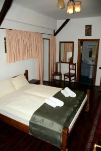 a bedroom with a bed with two towels on it at Pensiunea Cerbul - Valea Dobârlăului in Valea Dobîrlăului