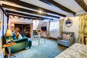 a living room with a green couch and a table at Eglantine in Crondall