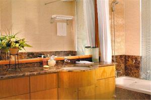 Un baño con lavabo, espejo y bañera. en Dalian Asia Pacific Service Apartment (Former Somerset Harbour Court Dalian), en Dalian 51 fotos más