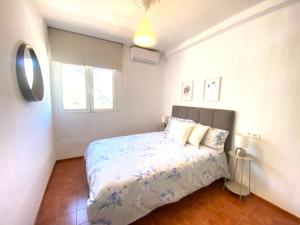 un dormitorio con una cama y una ventana en Charming And Cozy House in Agaete, en San Pedro