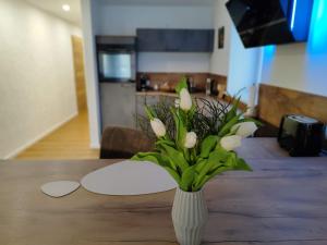 a vase with white flowers sitting on a table at Apartment Marissa - zentral - Parkplatz in Billerbeck