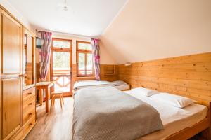 two beds in a room with wooden walls at Schronisko PTTK Orlica in Szczawnica