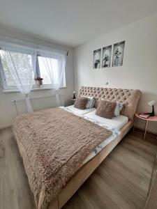 a bedroom with a large bed with a brown blanket at Ubytování Hrušky in Hrušky