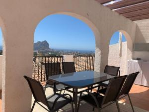 a table and chairs on a balcony with a view of the ocean at Imperial Park - Bungalow mit Panoramablick und schöner Terrasse in Calpe