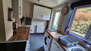 eine kleine Küche mit Spüle und Waschmaschine in der Unterkunft North Wales Cosy Cottage with views near Eryri Snowdonia in Nantlle + 23 Fotos