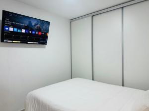 a bedroom with a bed and a flat screen tv at Apartamento Noori 1B in Vinarós