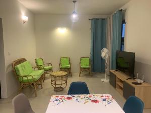 a living room with green chairs and a tv at LuxNar Beach GF in La Gaulette