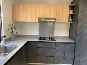 a kitchen with wooden cabinets and a stove top oven at LuxNar Beach GF in La Gaulette