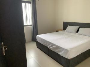 a bedroom with a bed with white sheets and a window at LuxNar Beach GF in La Gaulette