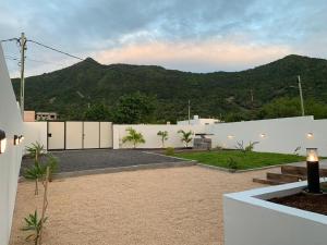 a backyard with a white fence and a mountain at LuxNar Beach GF in La Gaulette