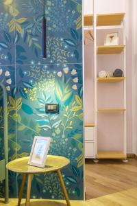 a room with a table and a wall with a floral wallpaper at Lucy's Flowers in La Spezia