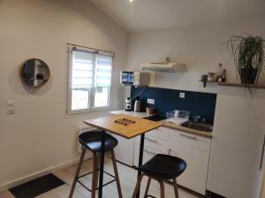 a kitchen with two stools and a table in it at Dépendance cosy in Longages