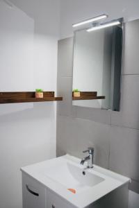 un bagno con un lavandino bianco e uno specchio di M T2 climatisé à100m de la plage ,des bateaux ,des commerces, Une terrasse ensoleillée a Palavas-les-Flots Altre 34 foto