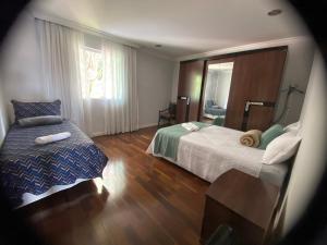 a hotel room with two beds and a window at Quarto amplo e confortável in Sao Paulo +8 photos