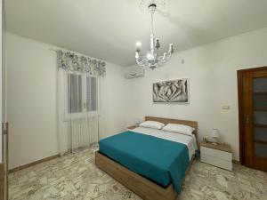 a bedroom with a blue bed and a chandelier at Villa Lucia appartamento Ischia in Leporano Marina