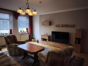 a living room with a table and a flat screen tv at FeWo Wittstock in Wittstock