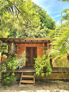 a small cabin with a wooden porch in a forest at Chalé Carnaval do Sol, Arraial d'Ajuda in Porto Seguro +8 photos