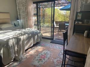 una camera da letto con un letto, una scrivania e un tavolo di Aloe Guesthouse Klerksdorp a Klerksdorp
