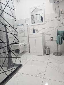 a white bathroom with a sink and a mirror at MIRO Apartmani in Pale