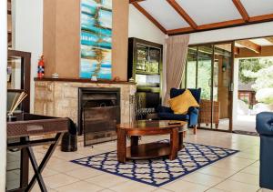 a living room with a fireplace and a table at Sand River Guest House in Johannesburg