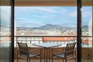 a table and chairs on a balcony with a view at Hyatt Regency Nice Palais de la Méditerranée in Nice