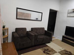 a living room with a couch and a television at anas MJ homestay private pool in Ayer Keroh