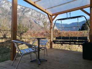a table and chairs on a porch with a view at Camping le Tréjeux - Petit Chalet in Thônes