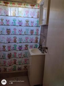 une salle de bain avec un rideau de douche avec des chats dessus dans l'établissement Juliana, à Santa Teresita