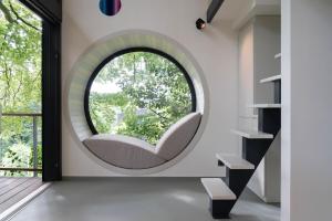 a circular window in a room with a white chair at Cube - K1 Baumhaus in Odenthal +6 photos
