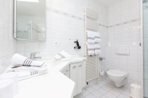Un baño blanco con lavabo e inodoro. en Finlandia Bungalow, en Süderende 13 fotos más
