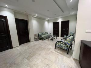 a living room with two chairs and a tv at برج العرب الجديدة الحي الثاني in Burj al ‘Arab al Jadīdah