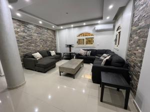 a living room with couches and a brick wall at برج العرب الجديدة الحي الثاني in Burj al ‘Arab al Jadīdah