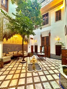a courtyard with a tree in a building at Riad Phœnix in Fès al Bali