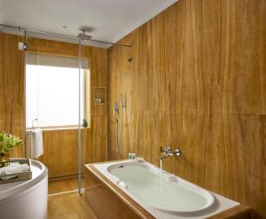 a bathroom with a large tub and a window at Storii By ITC Hotels, Jaisalmer in Jaisalmer