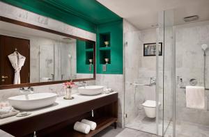 a bathroom with two sinks and a glass shower at Storii By ITC Hotels, Jaisalmer in Jaisalmer