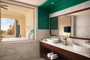 a bathroom with two sinks and a large mirror at Storii By ITC Hotels, Jaisalmer in Jaisalmer
