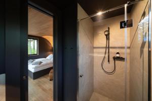 a bathroom with a shower and a bed in a room at Loop - K1 Treehouses in Odenthal