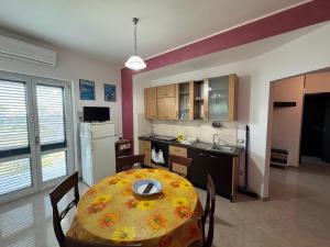 a kitchen and dining room with a table and a kitchen gmaxwell gmaxwell gmaxwell at CASA VACANZA BORGOROSSO A 70mt DAL MARE in Casa Borgorosso