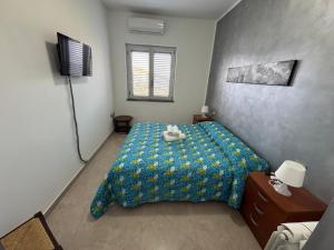 a bedroom with a bed with a blue comforter at CASA VACANZA BORGOROSSO A 70mt DAL MARE in Casa Borgorosso