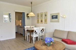 una sala de estar con un sofá y una mesa en Gartenstr. 2F, en Westerland