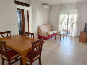 una sala de estar con una mesa y un sofá en Altos de la bahia DaNuria,es, en Torrevieja