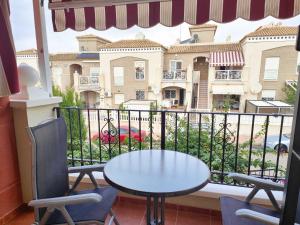 Una mesa y sillas en un balcón con vista a un edificio. en Altos de la bahia DaNuria,es, en Torrevieja