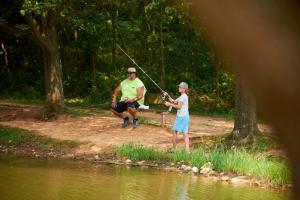 a man and a woman fishing in the water at Jellystone Mammoth Cave in Cave City