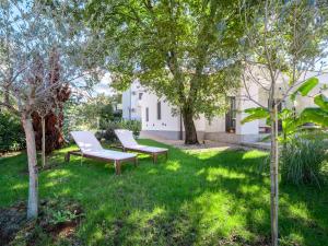 two chairs and trees in the yard of a house at Casa Dea in Malinska