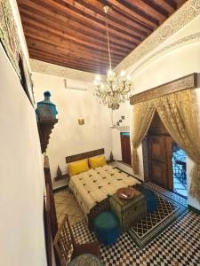 a bedroom with a bed and a chandelier at Riad Phœnix in Fès al Bali +118 photos