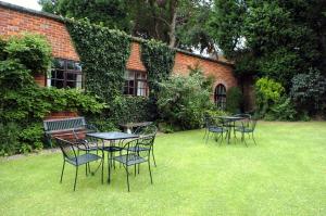 um grupo de mesas e cadeiras num pátio em Donington Manor Hotel em Castle Donington